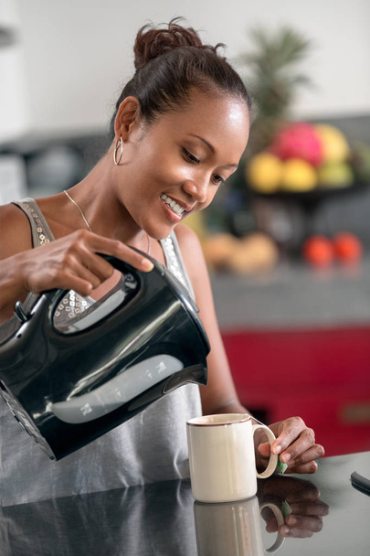 woman on her break pouring herself a mug of hot coffee - Foto, immagini