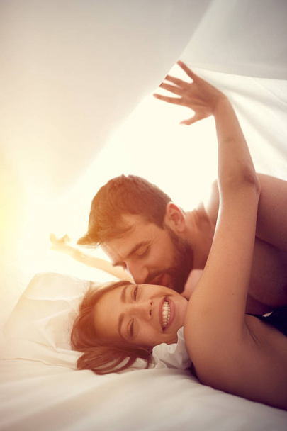 Ευτυχισμένο ζευγάρι μοιράζονται στενές στιγμές στο υπνοδωμάτιο - Φωτογραφία, εικόνα