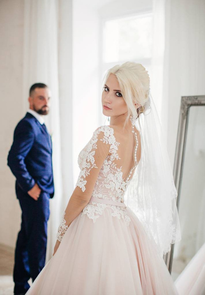 schöne junge Braut und Bräutigam posiert im Zimmer - Foto, Bild