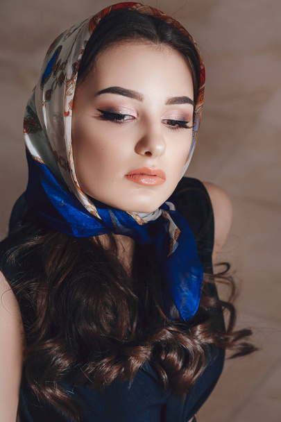 頭のスカーフでポーズ美しい若い女性 - 写真・画像