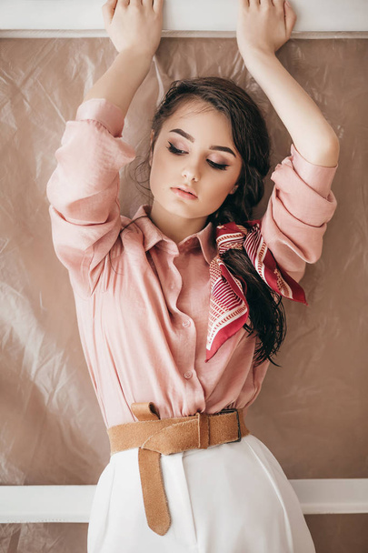 Hermosa joven posando en blusa rosa y pantalones blancos
 - Foto, imagen