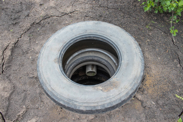poço de esgoto com pneus de carro
. - Foto, Imagem
