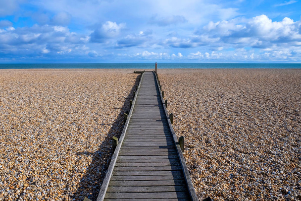 long sentier droit en bois sur la plage de galets
 - Photo, image