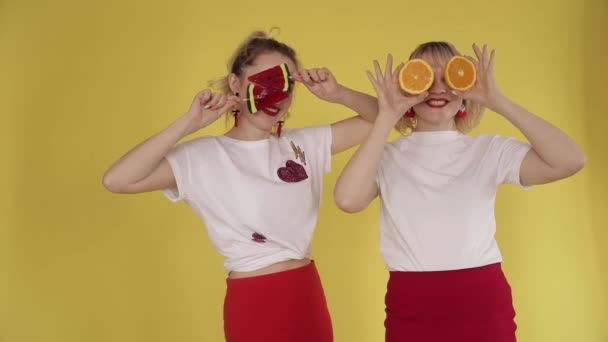 Gelukkige meisjes hebben feest en dansen op gele achtergrond - Video