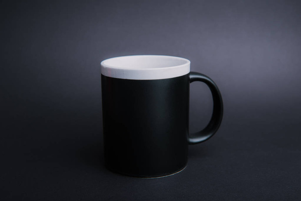 Photo d'une tasse noire, sur fond sombre et isolé
  - Photo, image