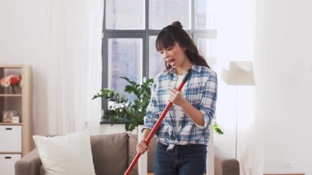 asian woman with broom sweeping floor and cleaning - Materiał filmowy, wideo
