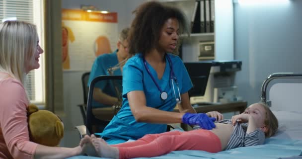 Kobieta lekarz badanie dziewcząt brzuch - Materiał filmowy, wideo