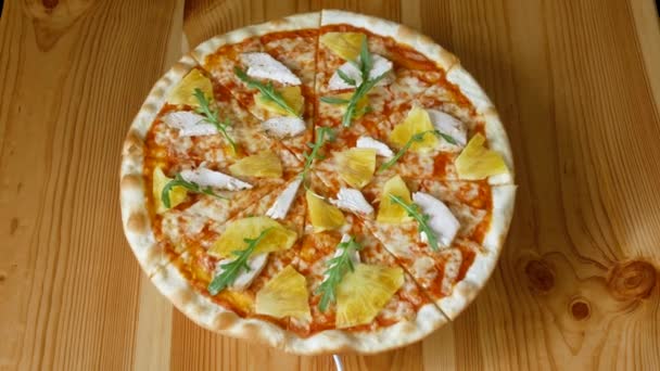 Pizza with pineapple and chicken spinning in a circle. Fast food. View from above - Footage, Video