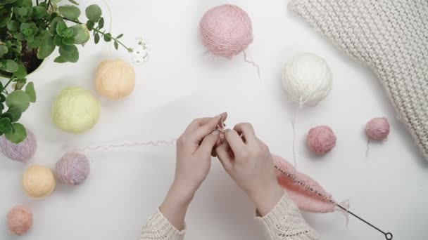 Mains féminines tricoter à partir de fil rose avec des aiguilles en acier. - Séquence, vidéo