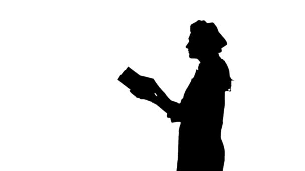 Черный силуэт женщины-повара с длинными волосами, читающей поваренную книгу
. - Кадры, видео