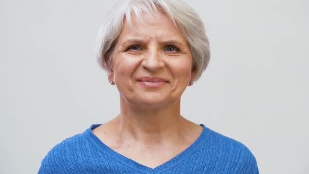 portrait of smiling senior woman over grey - Záběry, video