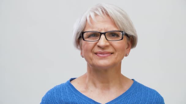 portrait of senior woman in glasses over grey - Filmagem, Vídeo