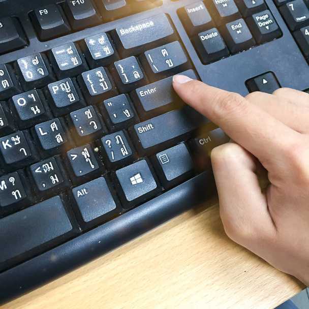 As mulheres estão usando o dedo para pressionar o botão ENTER no teclado do computador
 - Foto, Imagem