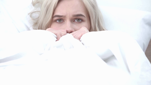 испуганная блондинка прячется и закрывает лицо, глядя на камеру в спальне
 - Кадры, видео
