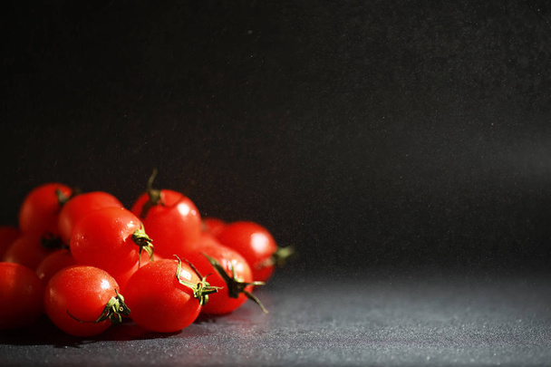 Черри помидоры на черном фоне в спрей
 - Фото, изображение