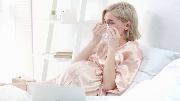 aufgebrachte blonde Schwangere weint, während sie sich Film auf Laptop im Schlafzimmer ansieht  - Filmmaterial, Video