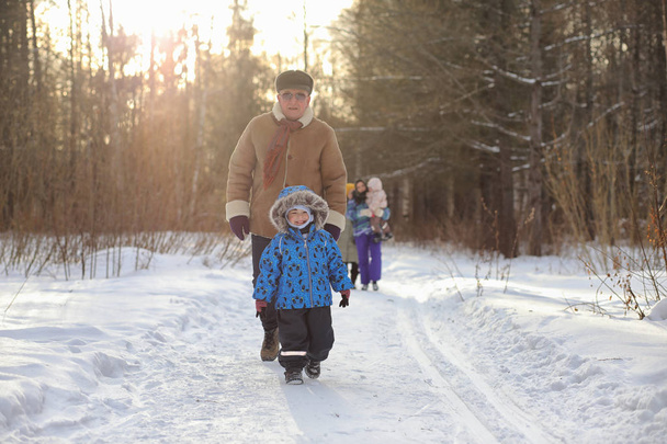 Kid running in winter park and have fun with family - Photo, Image