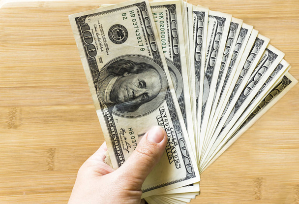 crolled στοίβα από 100 νέους λογαριασμούς δολαρίων σε φόντο ξύλινη - Φωτογραφία, εικόνα