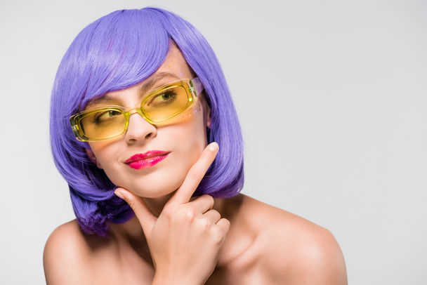 beautiful thoughtful girl in purple wig and sunglasses isolated on grey - Photo, Image