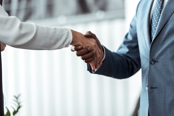 cropped view of businesswoman shaking hands with african american businessman  - Photo, image