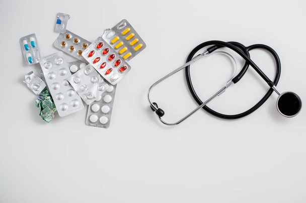 винтажный стетоскоп и лекарства на белом изолированном фоне
 - Фото, изображение