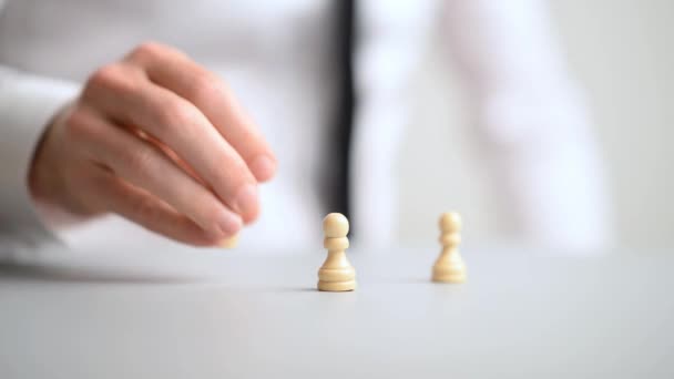 Businessman placing pawn chess pieces on office desk - Filmati, video