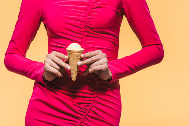 částečný pohled na stylovou dívku držící zmrzlinu, izolovanou na žluté - Fotografie, Obrázek