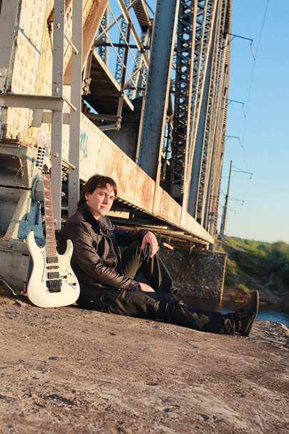 Homme avec une guitare électrique dans le paysage industriel extérieur
 - Photo, image