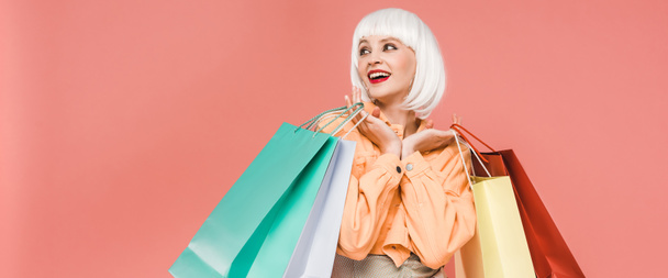 excited girl in white wig with shopping bags, isolated on pink - Photo, Image
