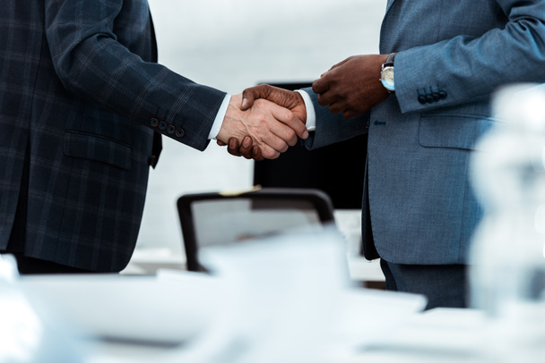 cropped view of african american businessman shaking hands with partner in office  - Photo, Image