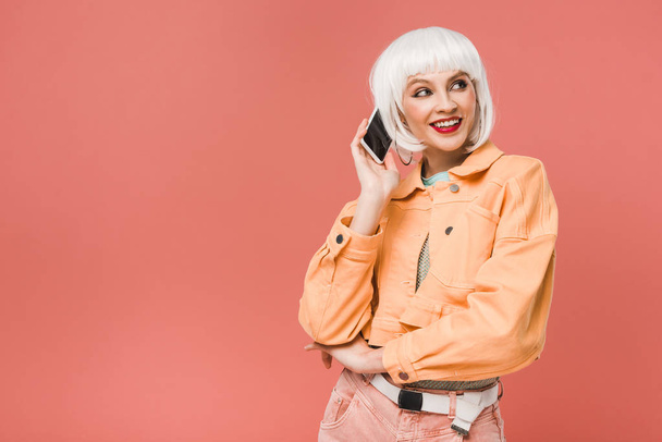 attractive smiling woman talking on smartphone, isolated on pink - Photo, Image