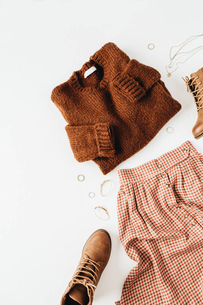Composición casual de moda con suéter marrón, zapatos, falda, accesorios sobre fondo blanco. Asiento plano, vista superior. collage minimalista moderno
. - Foto, Imagen