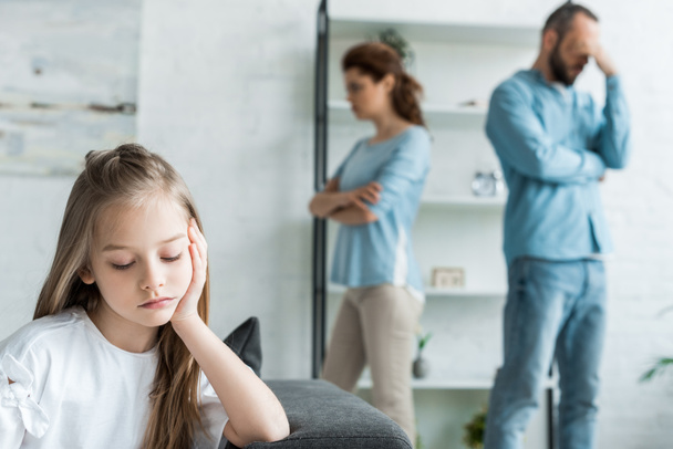 selective focus of sad kid near quarreling parents at home - Foto, immagini