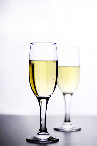 vetro di vino bianco su un tavolo su uno sfondo bianco isolato
 - Foto, immagini