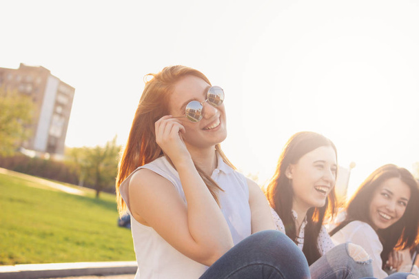 Група молодих щасливих подруг насолоджується життям на літній міській вулиці, фоні заходу сонця
 - Фото, зображення