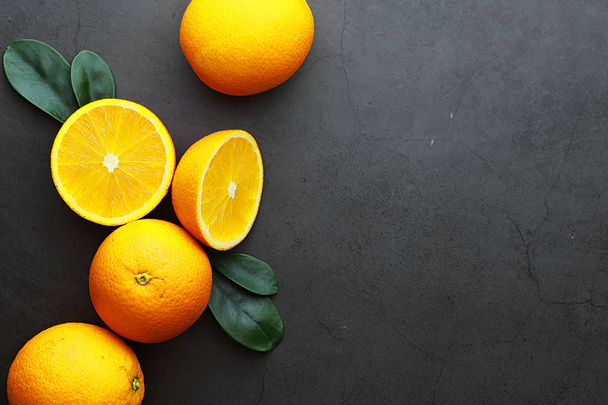 Owoce cytrusowe pomarańczowe na kamiennym stole. Tło pomarańczowe. - Zdjęcie, obraz