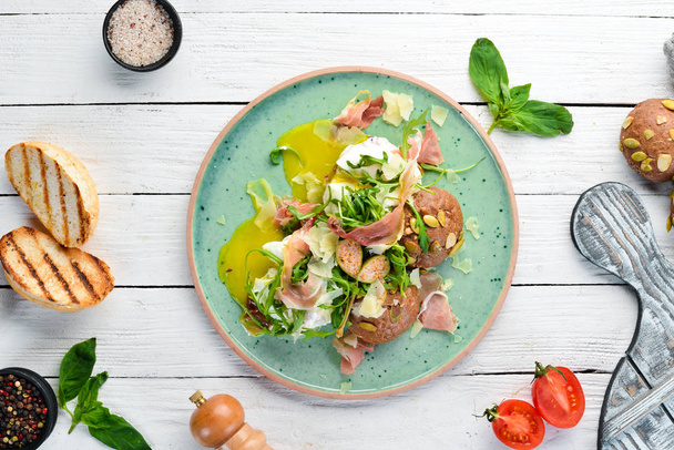 Sandwich with proshutto, egg and arugula. Breakfast. In the plate. Top view. Flat lay composition Free copy space. - Photo, image