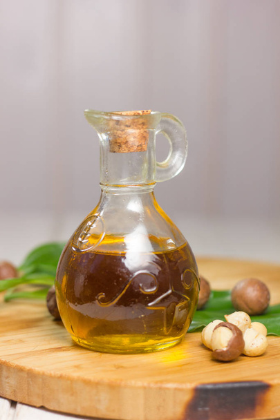 Macadamia oil in a glass bottle. Great photo for your needs.  - Фото, изображение