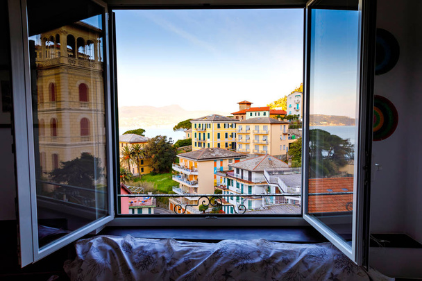 Lélegzetelállító kilátás az ablakból az olaszországi Liguria régióra. Zoagli, Cinque Terre és Portofino falvainak félelmetes falvai. Gyönyörű olasz város színes házakkal. - Fotó, kép