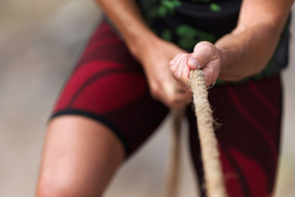 Cabo de guerra mãos masculinas segurando uma corda
 - Foto, Imagem