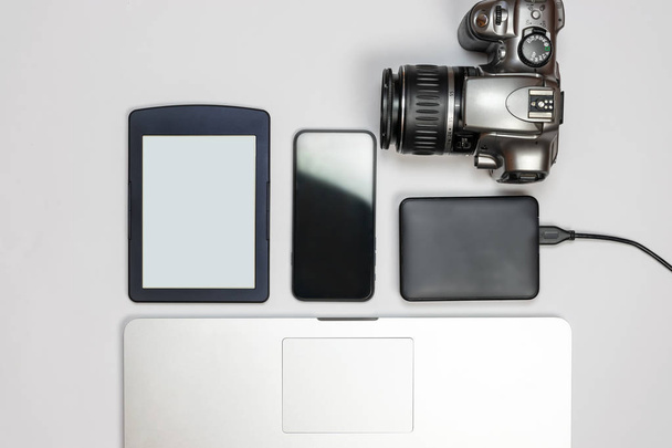 Spazio di lavoro con computer portatile, smartphone e altri gadget su un tavolo bianco, vista dall'alto
 - Foto, immagini