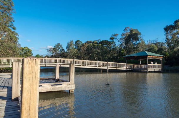 Drewniana grota przekraczania Ringwood Lake w zewnętrznych wschodnich przedmieściach Ringwood, Melbourne. - Zdjęcie, obraz