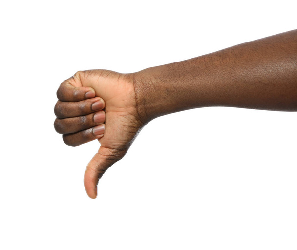 Αφροαμερικανός άνθρωπος δείχνοντας αντίχειρας κάτω χειρονομία σε λευκό φόντο, κοντινό πλάνο - Φωτογραφία, εικόνα