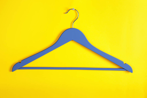 Empty clothes hanger on color background. Wardrobe accessory - Zdjęcie, obraz