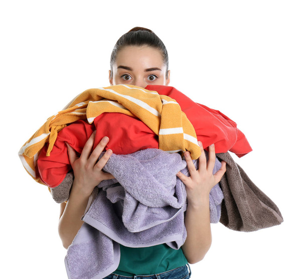 Young woman holding pile of dirty laundry on white background - Valokuva, kuva