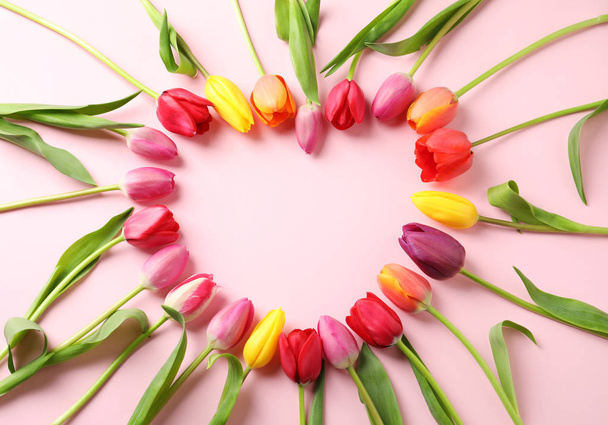 Heart made of beautiful tulip flowers on color background, flat lay. Space for text - Fotoğraf, Görsel