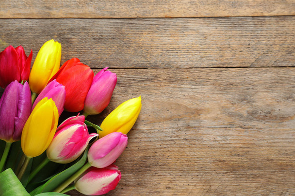 Beautiful tulips and space for text on wooden background, top view. Spring flowers - Fotoğraf, Görsel
