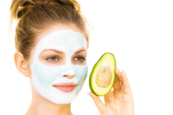 Ragazza maschera di fango facciale tiene frutta avocado
 - Foto, immagini