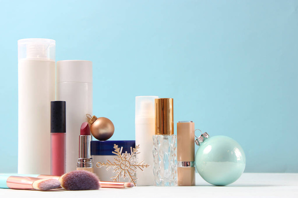 Conjunto de cosméticos decorativos profesionales y accesorios navideños en un fondo de color. - Foto, Imagen