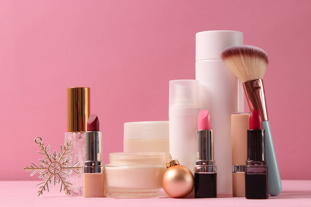 Conjunto de cosméticos decorativos profesionales y accesorios navideños en un fondo de color. - Foto, imagen
